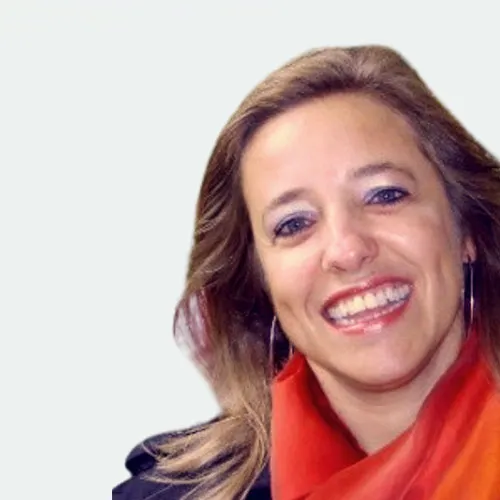 Lächelnde Frau mit langen blonden Haaren, die einen roten Schal und ein schwarzes Oberteil trägt, vor einem hellen Hintergrund.